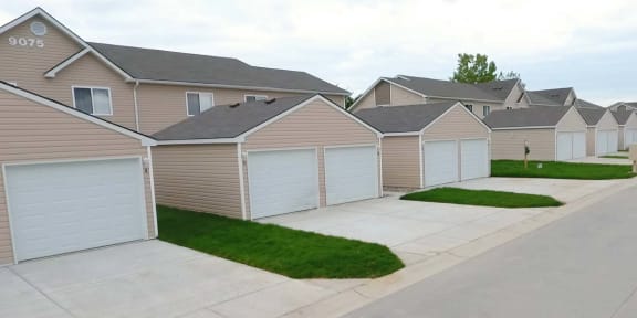 a row of houses with white garage doors