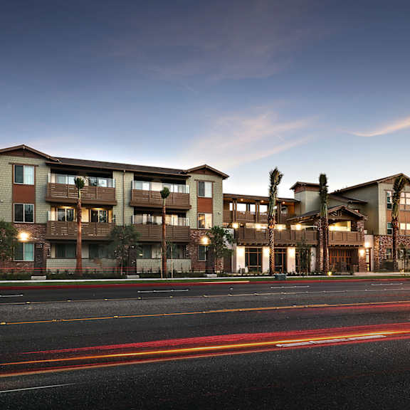 The front of the Mesa Vista Apartments building with a flag flying in the background.