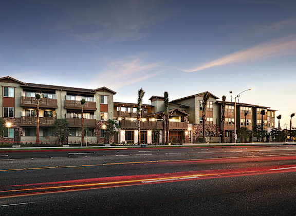 A long building with a lot of windows and lights on the street.