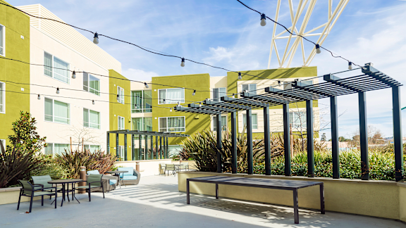 a patio with tables and chairs in front of a building