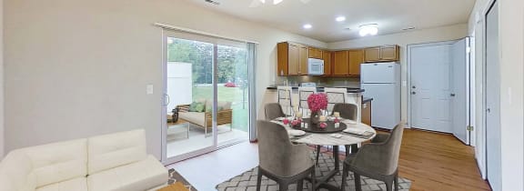 a living room and kitchen with a table and chairs