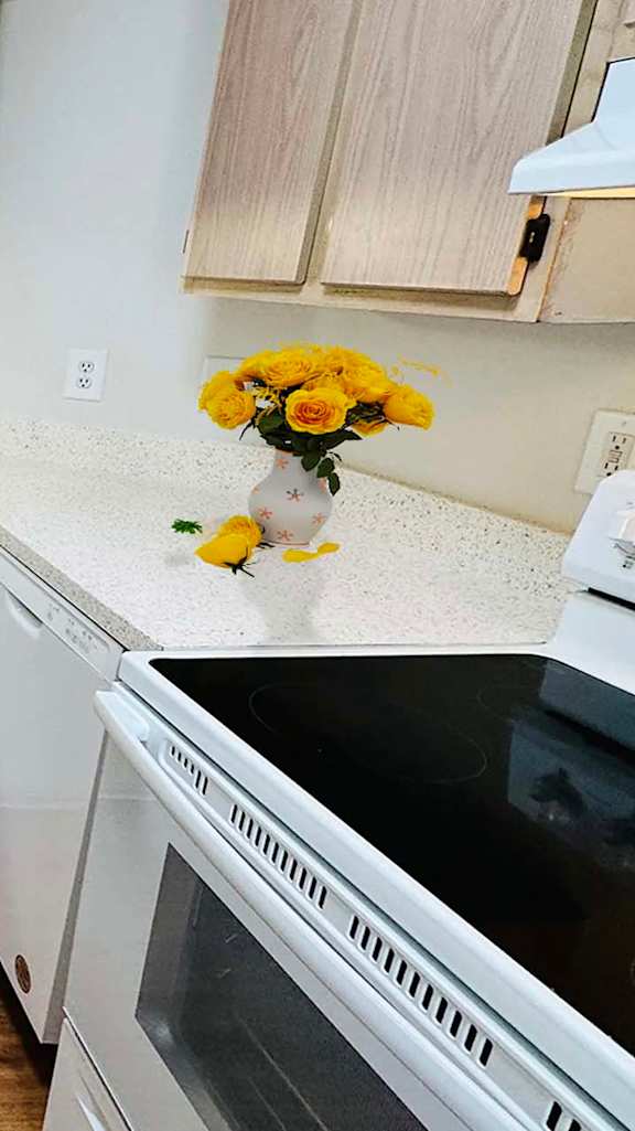 A kitchen with white appliances and wooden cabinets.
