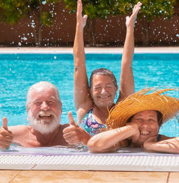 Four people are enjoying a day in a swimming pool.
