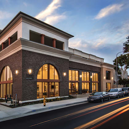 A modern building with a parking lot in front.