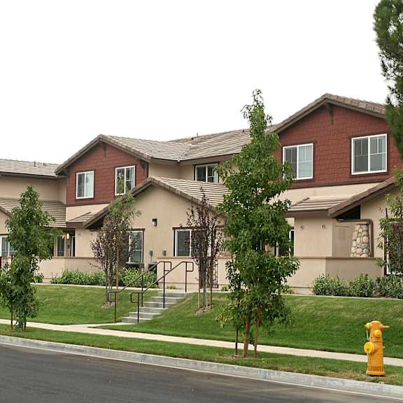 The front of the Mesa Vista Apartments building with a flag flying in the background.