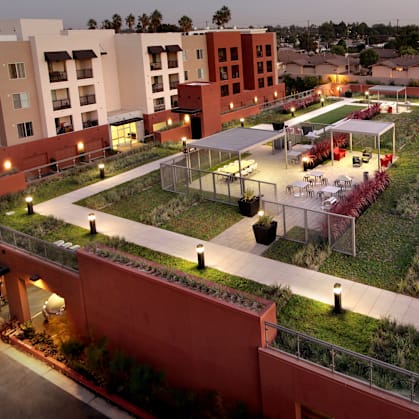 A courtyard with a fence and a green lawn.
