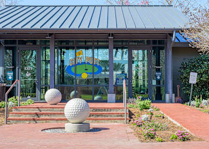 A building with a sign that says City Putt in front of it.