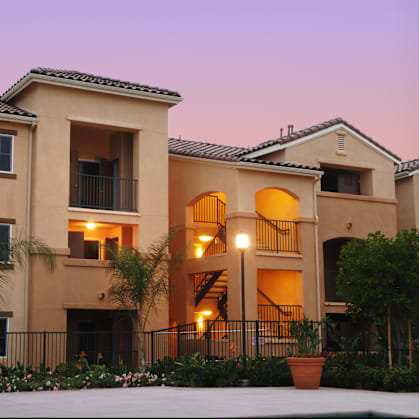 A large, two-story house with a balcony and a staircase.