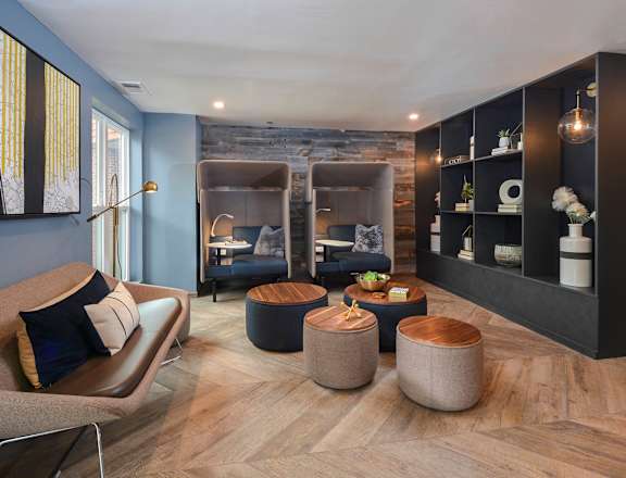 a living room with blue walls and wood floors and furniture at The Citizen at Shirlington Village in Arlington, Virginia