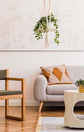 A grey couch with a white throw blanket on it.