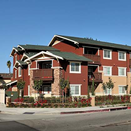 Apartment building with red brick and green roofs.