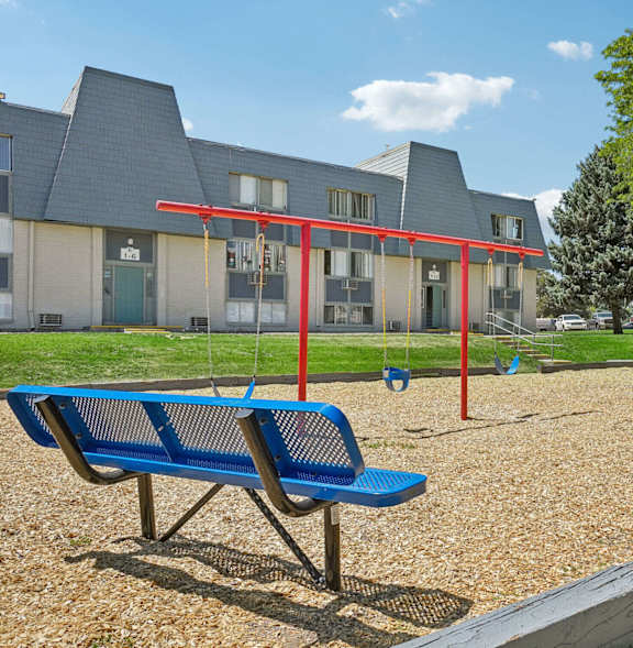 A playground with a slide and a tree in the background.