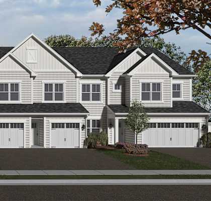 A large, two-story house with a black roof and white walls.