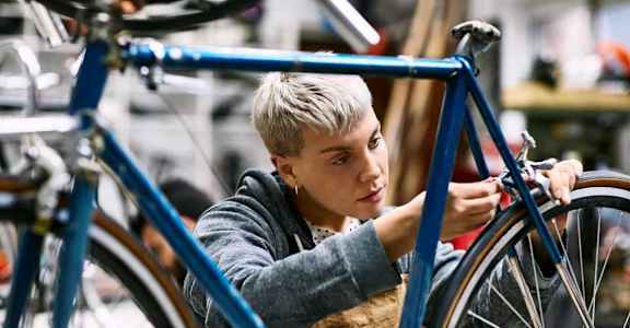 a young boy working on a bike in a workshop