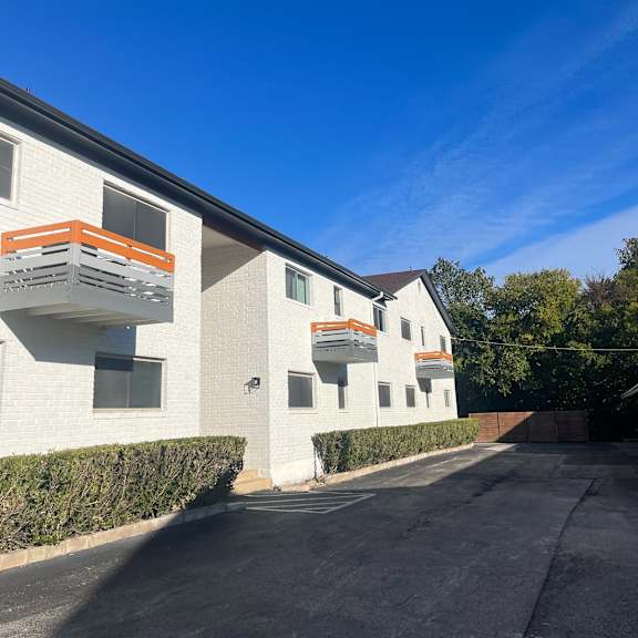 A white building with orange accents and a clear blue sky.