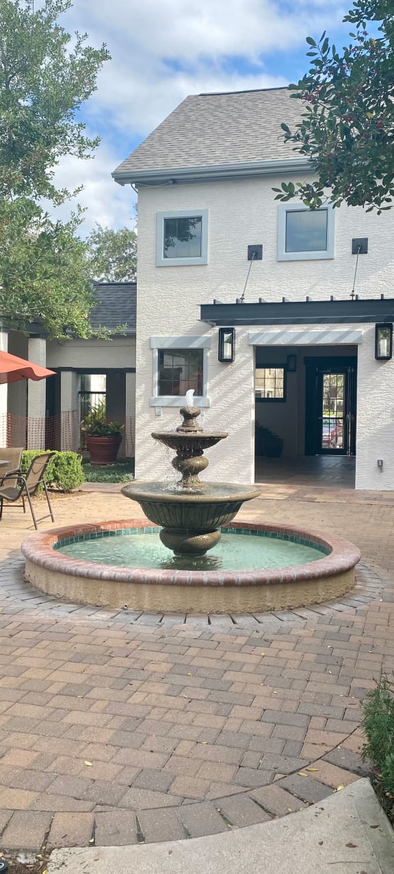 a swimming pool with chairs and a house in the background at Summerwind in Pearland 77584
