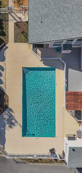 A rectangular pool with a concrete floor and a concrete wall surrounding it.