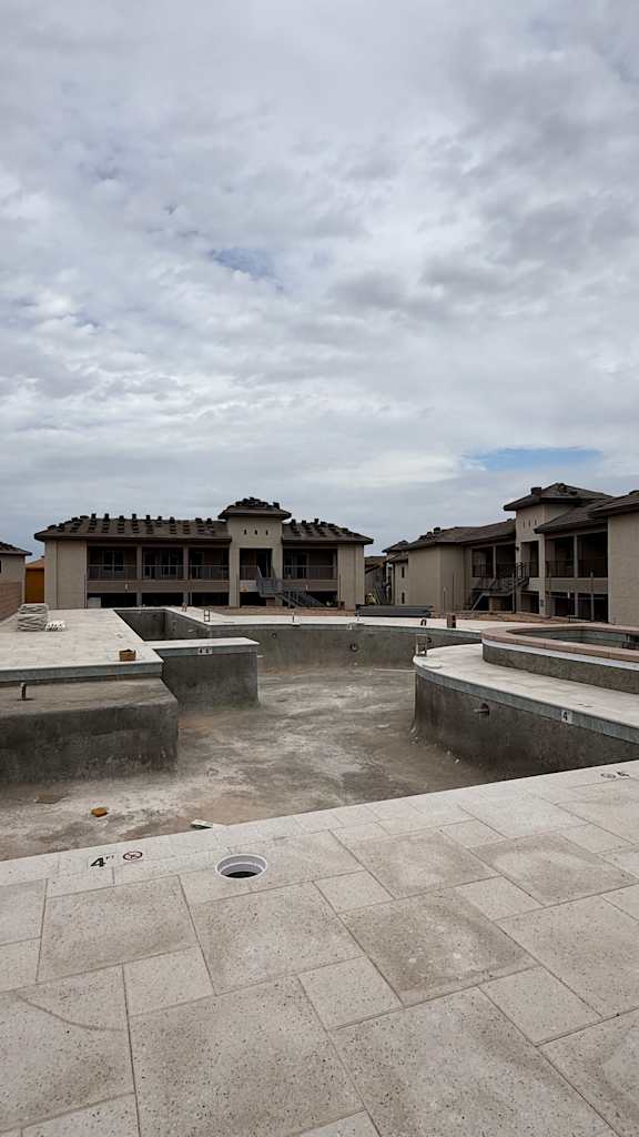 A courtyard with a pool and a building in the background.