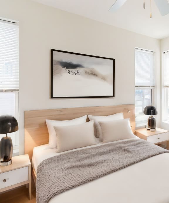 a bedroom with a bed and two windows