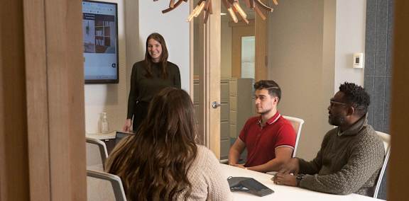A woman is giving a presentation to a group of people in a conference room.