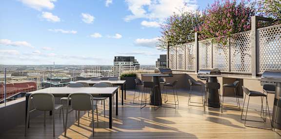 A patio with a table and chairs overlooking a cityscape.