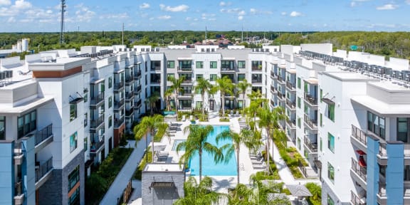 an aerial view of an apartment complex with a pool and palm trees at 19 South Apartments in Kissimmee, FL