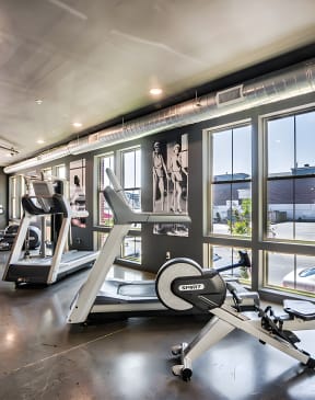 a workout room with treadmills and other exercise equipment
