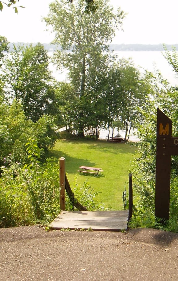 a sign for a park with a view of a lake