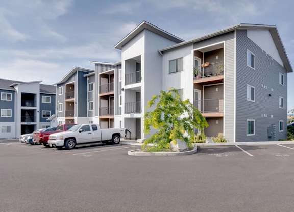 A white truck is parked in front of a grey building.