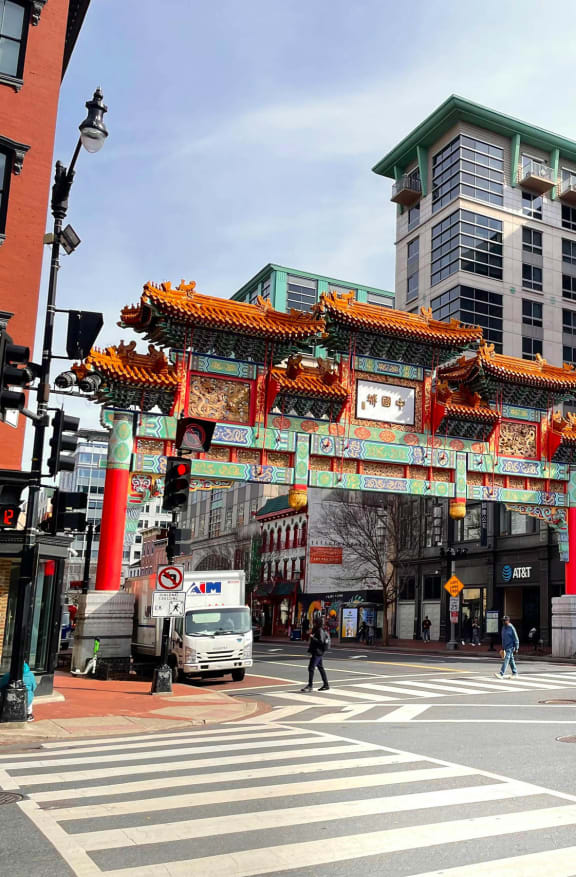 a busy city street with a large oriental archway in the middle