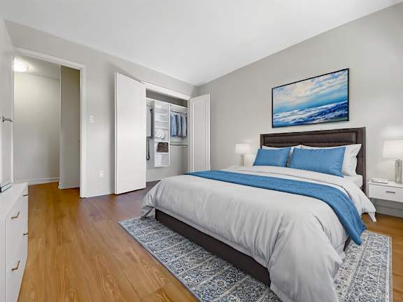 A bedroom with a large bed and a painting on the wall.