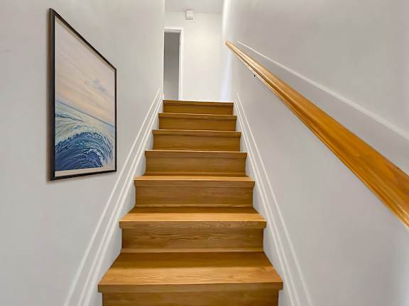 A staircase with a painting on the wall.