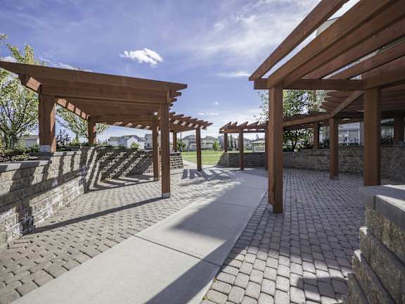 a covered walkway with a stone wall and wooden beams