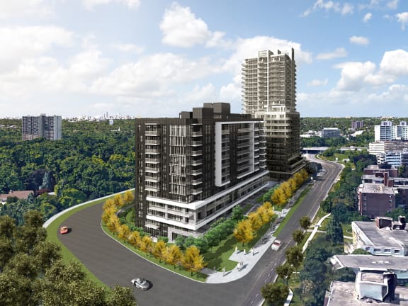 an aerial view of a tall building next to a road and trees