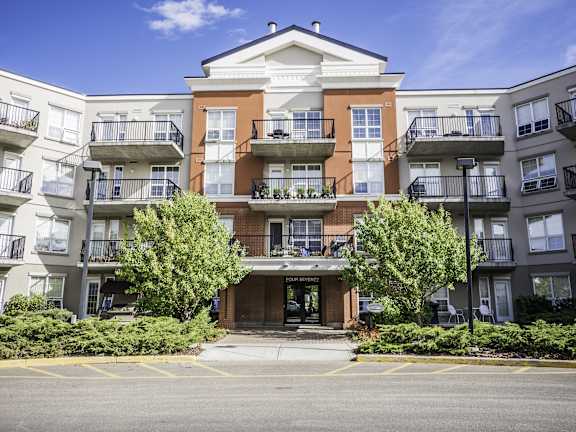 an apartment building with three balconies and a street in front