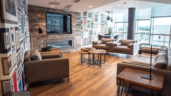 A modern living room with a stone wall and a flat screen TV.