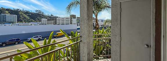 A balcony with a view of the ocean and buildings.