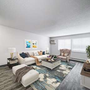 A living room with a white couch, a coffee table, and a television at The Ridges Apartments, Des Moines