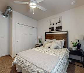 a bedroom with a bed and a ceiling fan at Melbourne Apartments, IA, 50320