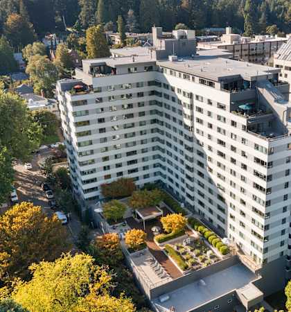 an aerial view of a large white building surrounded by trees