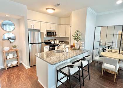 A kitchen with a granite countertop and stainless steel appliances.