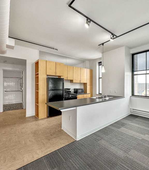A spacious office with a kitchenette and a view of the city at The Des Moines Building Apartments, Des Moines