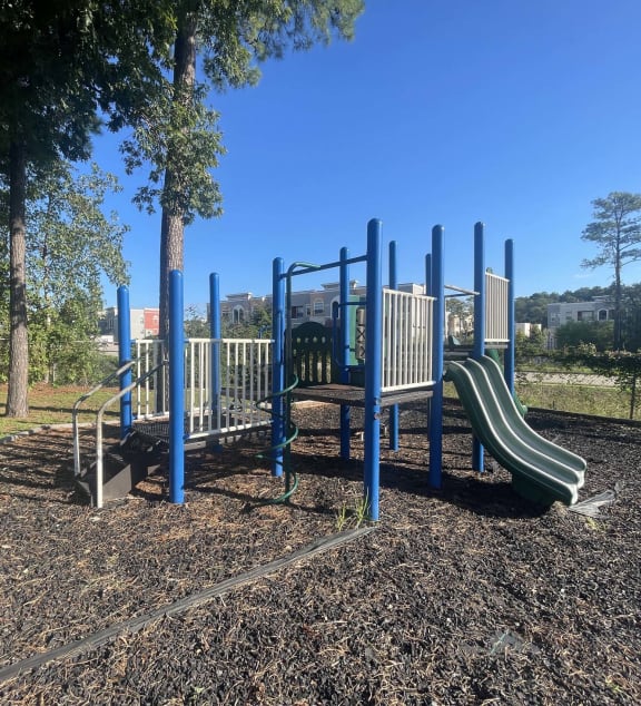 a playground with slides and benches in a park at Whispering Oaks in  Conroe, TX