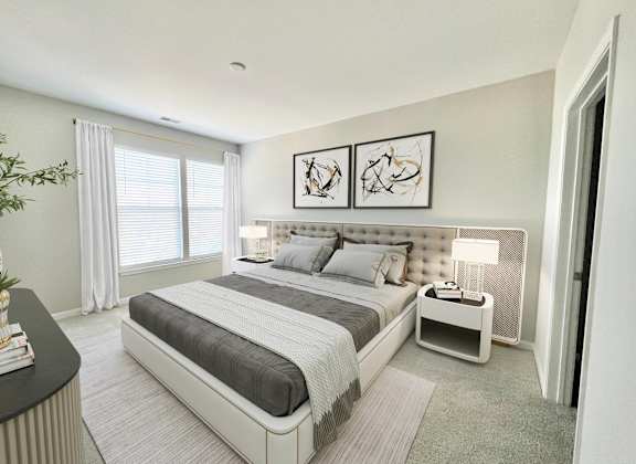 A modern bedroom with a large bed and a small nightstand.