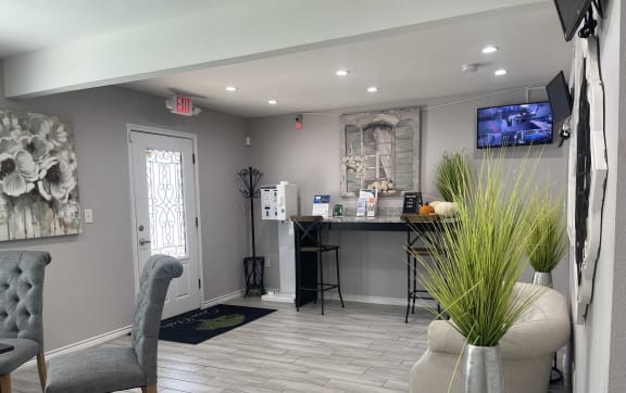 a living room with a couch and a chair and a kitchen in the background at Tara Oaks in Houston, TX