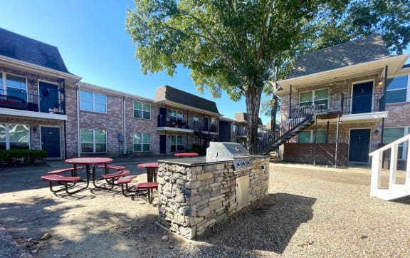 our apartments have a spacious courtyard with a grill and picnic table at Tara Oaks in Houston, TX