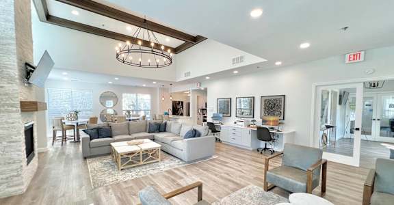 A spacious living room with a fireplace and a variety of seating options.