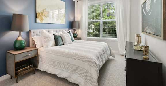 A bedroom with a bed, nightstand, and a ceiling fan.