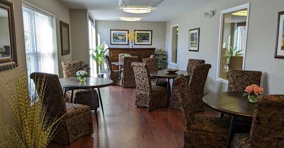 A living room with brown patterned chairs and a wooden floor.