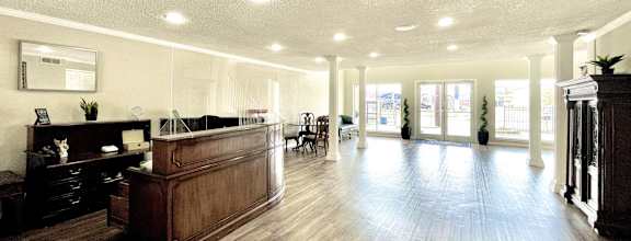 a lobby with a reception desk and a large room with hard wood floors at Cambridge Village in Houston, TX